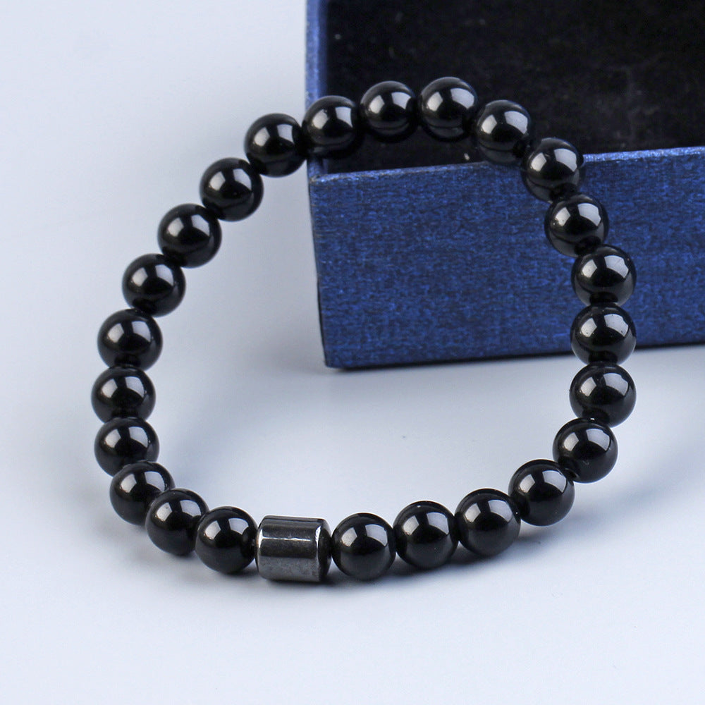 Black Onyx and Tiger Eye natural stone beaded bracelet on a glossy black surface