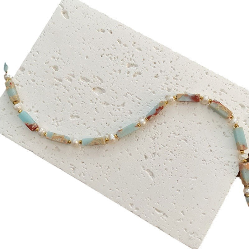 Delicate clavicle chain necklace featuring polished natural stone beads